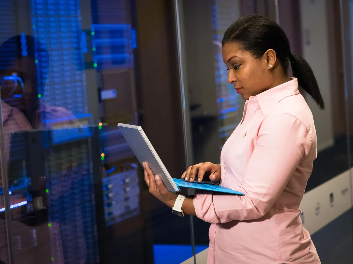 Engineer working on a laptop inside a server room