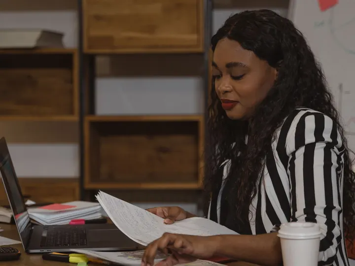 Professional reading a document at an office desk