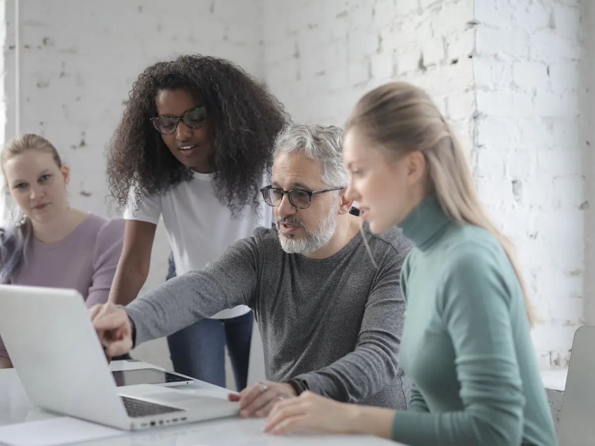 A team reviewing work together on a laptop